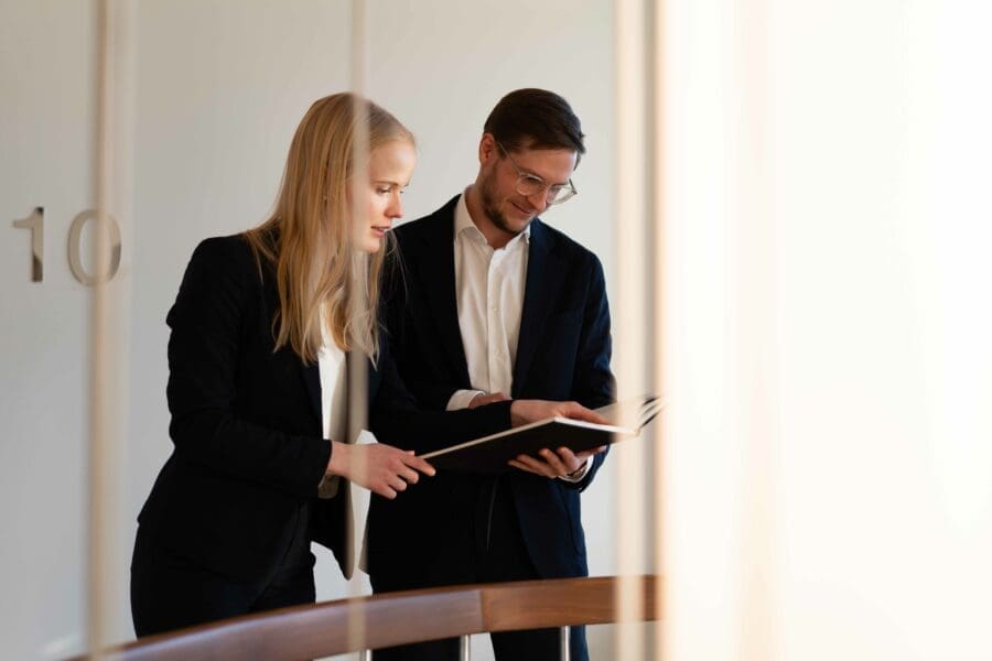 Två personer som har ett samtal och pekar i en bok
